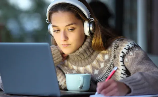 Student e-learning in a coffee shop in winter